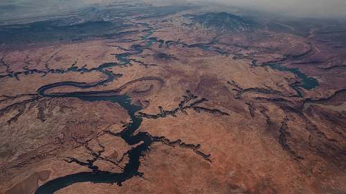 landscape aerial photo of brown mountains and river river